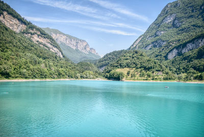 Scenic view of sea by mountains against sky
