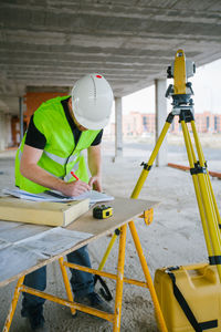 Surveyor engineer working at construction site with measuring equipment (total station)