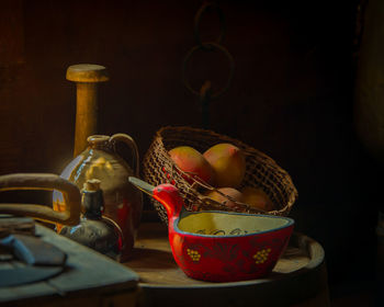 Close-up of fruits in basket on table against wall