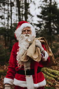 Man wearing santa costume carrying sack