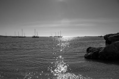 Sailboats in sea against sky