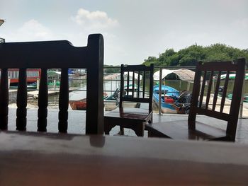 Chairs and table by sea against sky