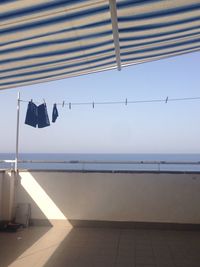 Clothes hanging over sea against clear sky