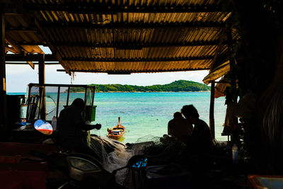 People sitting on chair by sea
