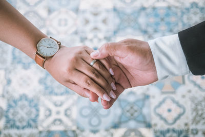 Midsection of couple holding hands