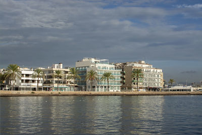 Exterior of buildings by sea against sky in city