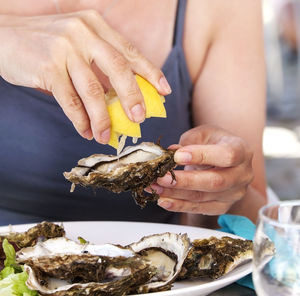 Woman eat oysters with lemon