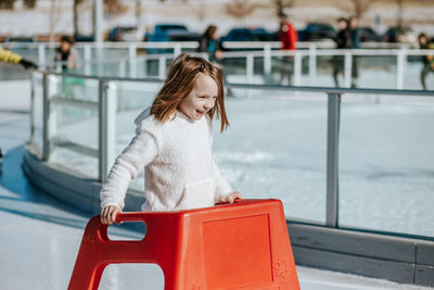 Young girl learning how to ice skate on a sunny winter day