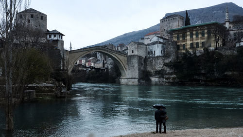 Man on bridge over water against sky