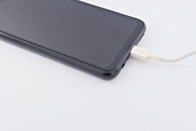 High angle view of smart phone against white background