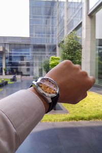 Midsection of man with umbrella on building in city