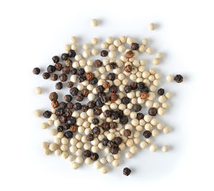 Directly above shot of black pepper and beans on white background