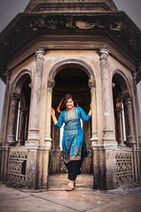 Full length of woman walking in archway of old building