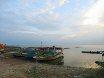 Boats moored on sea against sky
