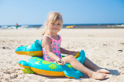 Portrait of young woman sitting at beach