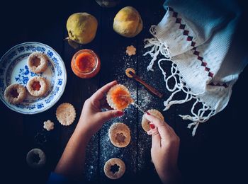 Cropped hands of woman preparing cookie on table