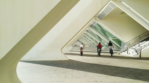 Rear view of children riding bicycle in triangular tunnel