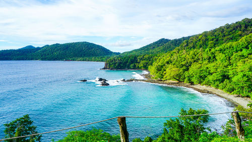 High angle view of sea and mountains against sky