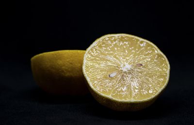 Close-up of lemon slice on table against black background
