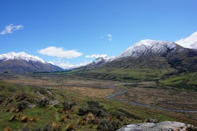 Scenic view of snowcapped mountains against blue sky