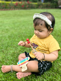 Portrait of boy playing with toy on field 1 year old