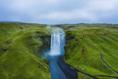 Scenic view of waterfall against sky