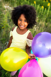 Portrait of smiling girl holding balloons