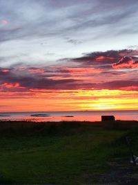 Scenic view of dramatic sky over land during sunset