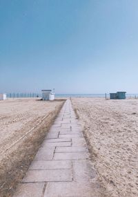 Walkway at beach against sky