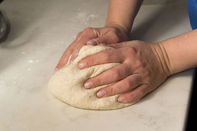 Cropped image of person preparing dough