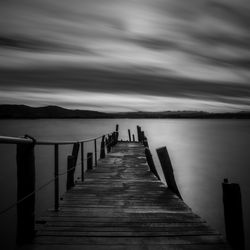 Pier over sea against sky at dusk