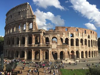 Tourists at historical building against sky