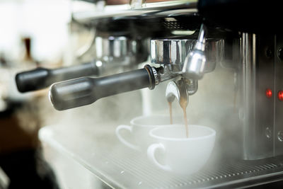 Coffee machine espressos shot and smoke in white cups