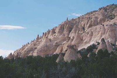 Low angle view of rocky mountains against sky