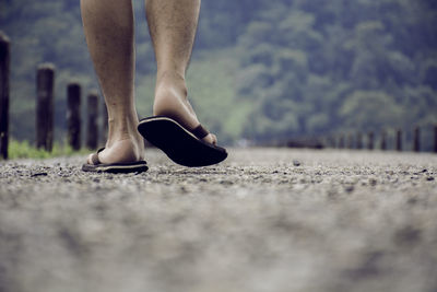 Low section of man walking on street