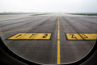 Airplane on airport runway against sky