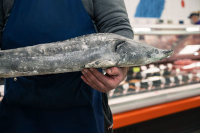 Midsection of man holding fish