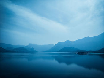 Scenic view of lake and mountains against sky