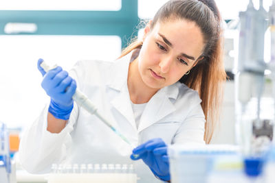 Young woman using mobile phone in laboratory