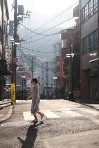 Full length of woman walking on road in city