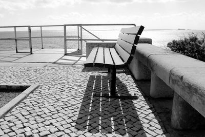 Empty bench at observation point against sea
