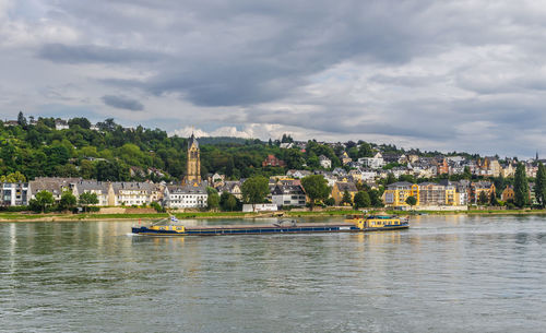 Scenic view of river by buildings against sky