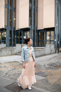 Beautiful woman standing against building in city