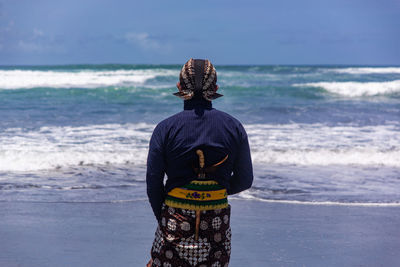 Rear view of man standing at beach