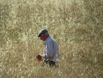 Man standing amidst grassy field