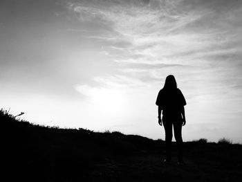 Silhouette man standing on field against sky