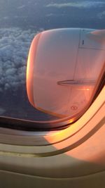 Close-up of airplane wing against sky during sunset