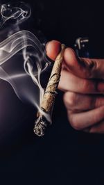 Close-up of hand holding cigarette