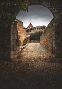 Footpath amidst buildings against clear sky