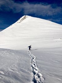 Person on snowcapped mountain against sky